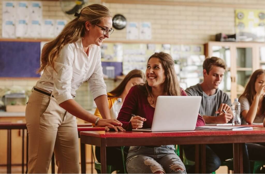 Confident teacher smiling in front of STEM classroom