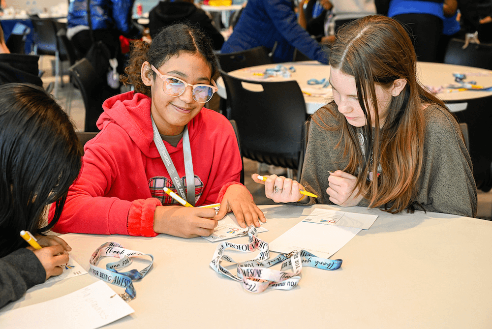 Group of girls collaborating on letters to go with self-care package activity at Class Matters E-STEAM event